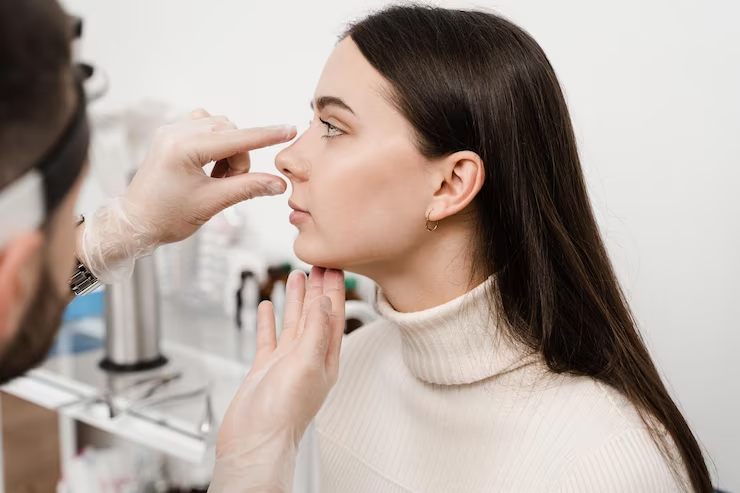 Aesthetic practitioner examining a patient’s nose before a non-surgical nose job in London.